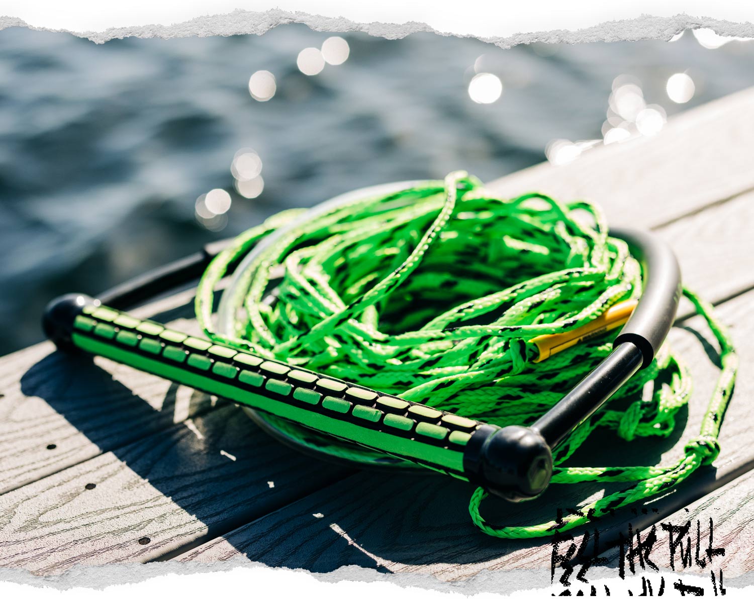 Angled view of Liquid Force TR9 handle with green rope coiled on dock.