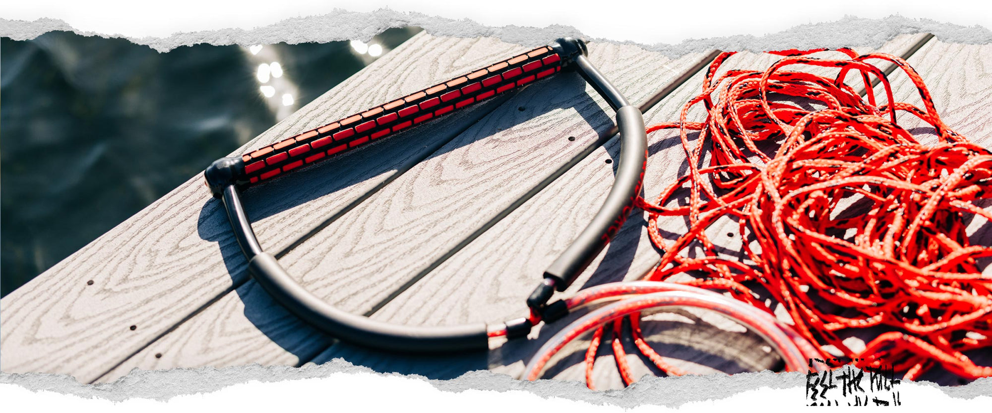 Red Liquid Force TR9 handle with red rope coiled on dock.