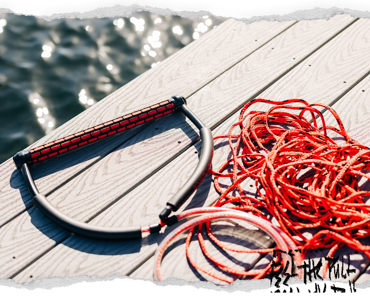 Red Liquid Force TR9 handle with red rope coiled on dock.
