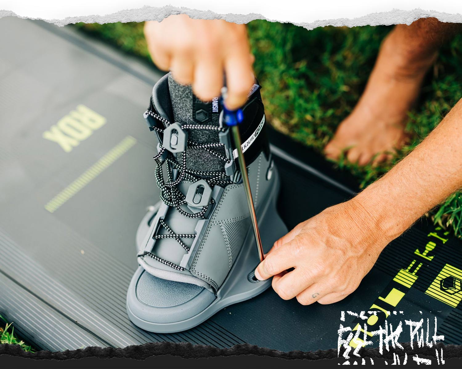 Close-up of grey Liquid Force binding being attached to a black RDX board.