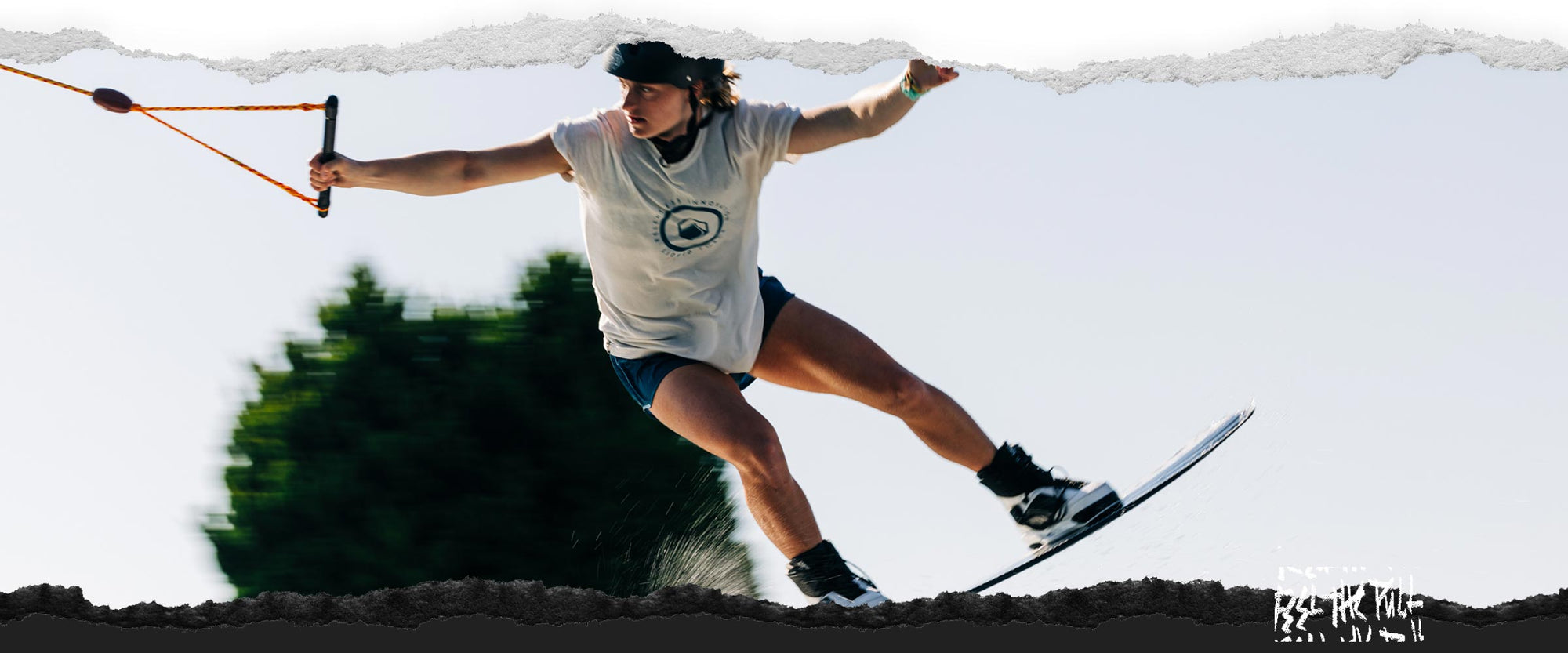 Wakeboarder in white shirt and helmet riding the Liquid Force Virago wakeboard.
