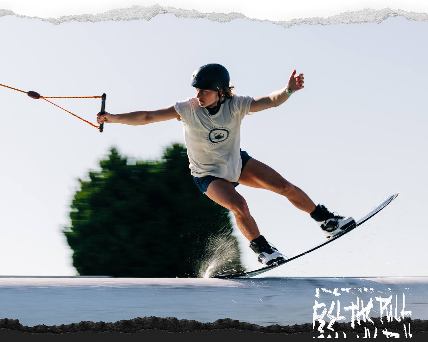 Wakeboarder in white shirt and helmet riding the Liquid Force Virago wakeboard.