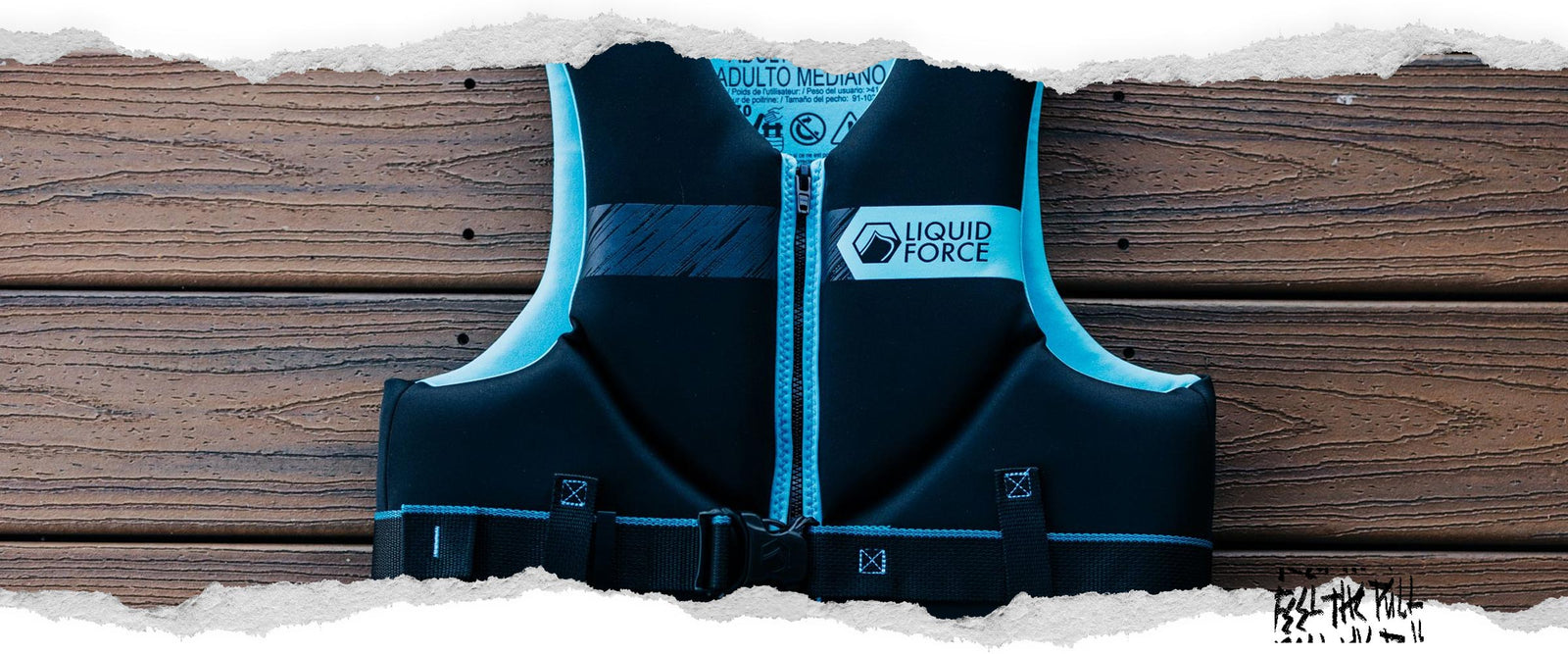 Chaleco CGA Classic Hinge en color negro y aguamarina con el logotipo de Liquid Force colocado sobre tablones de madera.