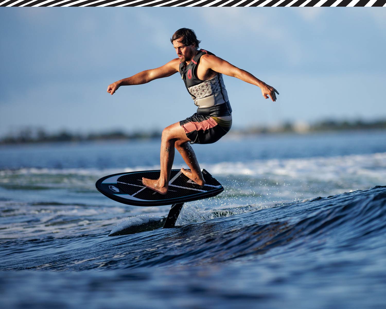 Rider foiling smoothly on Carbon Horizon 1200 FuseLock front wing across gentle blue water.