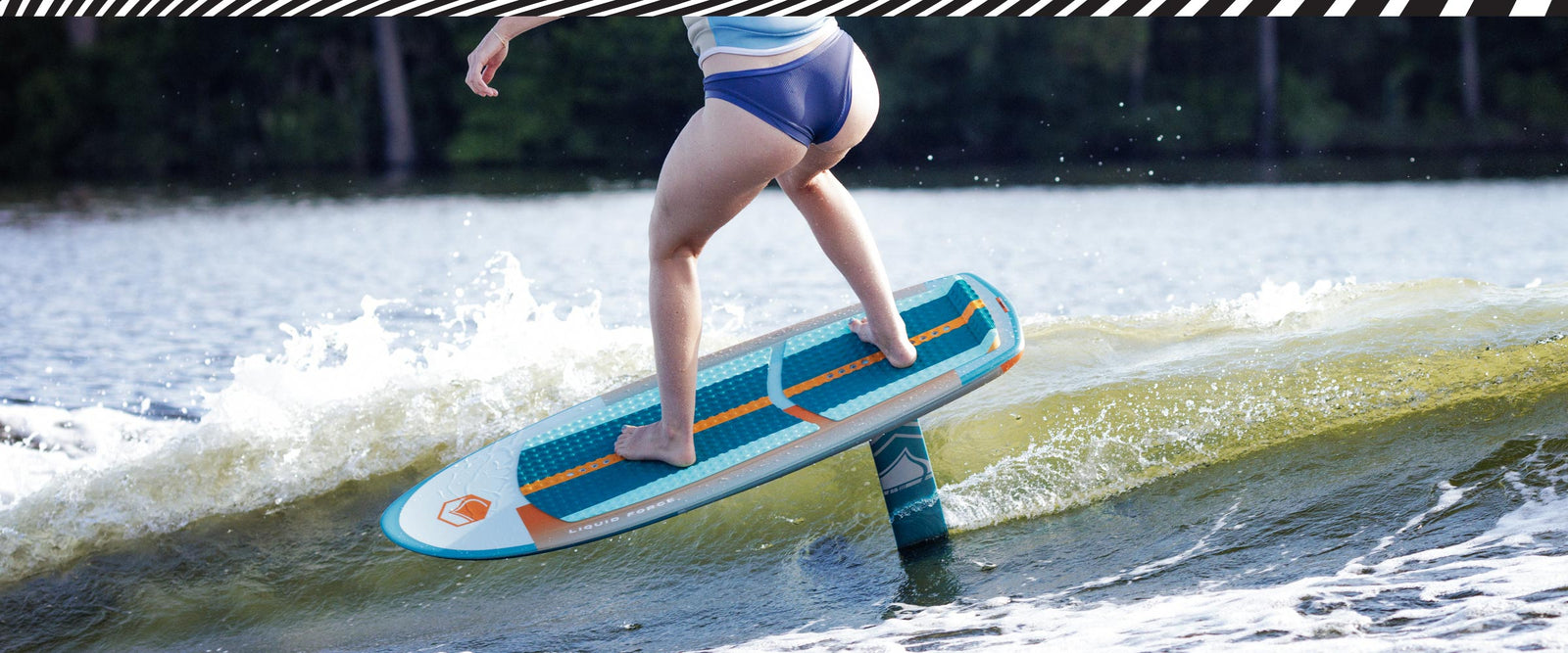 Rider glides on Horizon Surf foil setup above small wave in bright sunlight.
