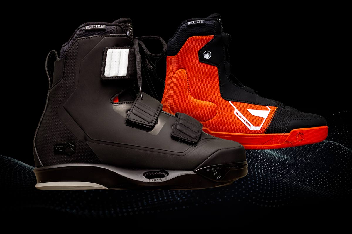 Close up of black and orange Hook 4D wakeboard bindings on a black background.