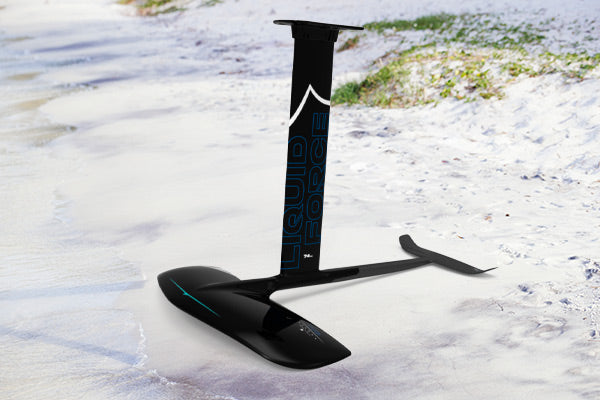 Liquid Force Carbon foil standing on its own standing in the sand.