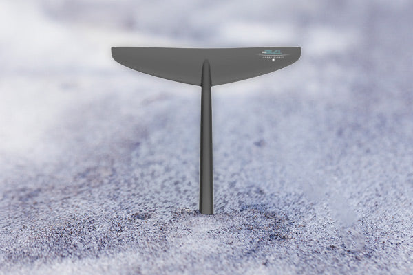 Tail of a fuselock foil standing straight up in the sand